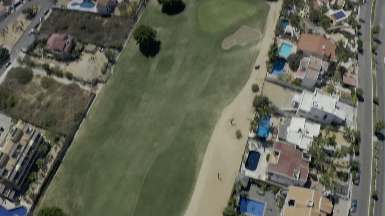 The second frame looks down over a Los Cabos golf fairway with sand traps, nearby houses, blue swimming pools, a road, and dry open lots, with no visible people.