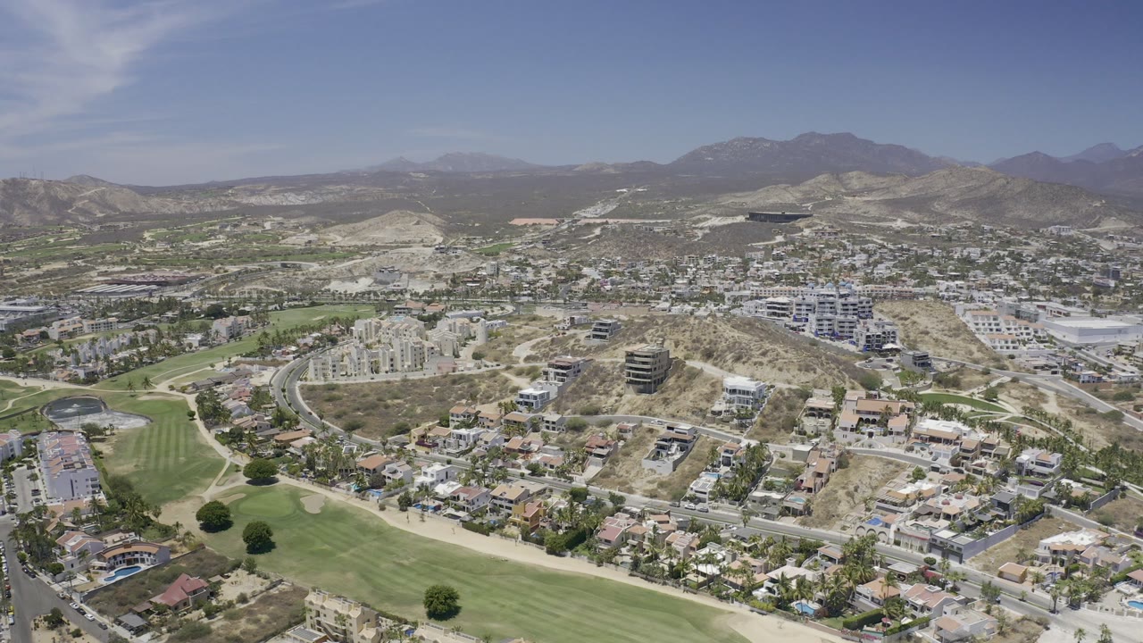 Aerial view of hillside city development beside a golf course