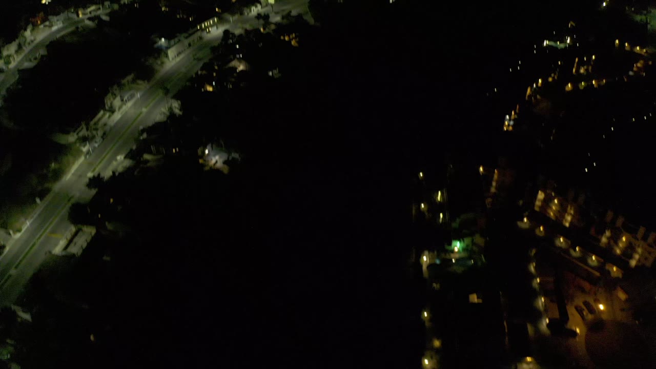 Dark overhead city view with roads and scattered lights
