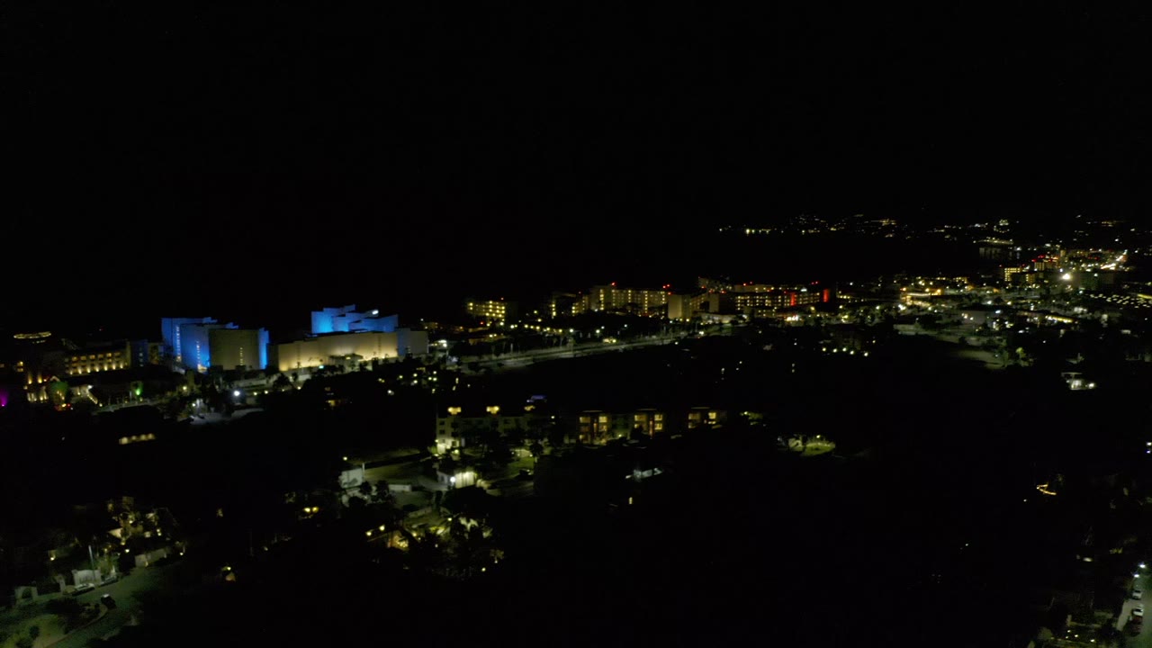 Aerial city lights with blue-lit building at night