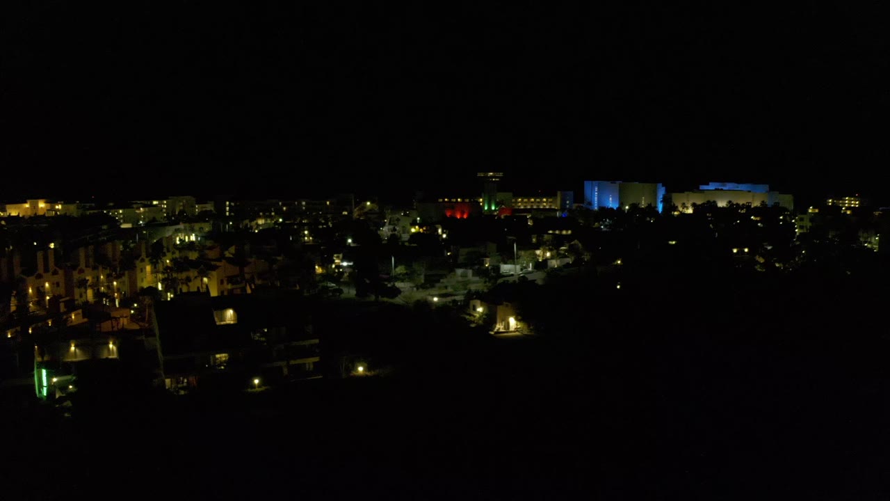 Quiet nighttime townscape with scattered lights and dark trees.