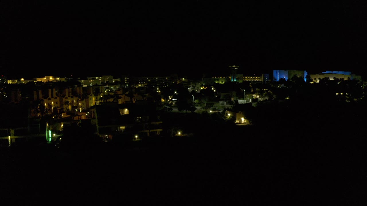 Dark night view with distant building and home lights.