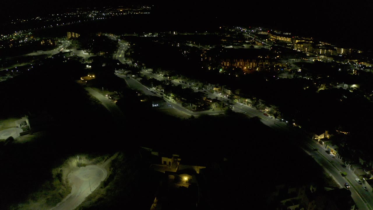 Night aerial view of lit roads and dark open land