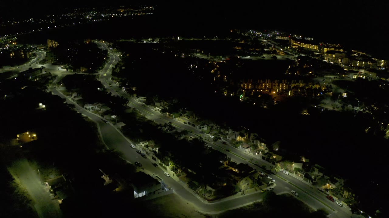 Dark aerial cityscape with roads and lit buildings