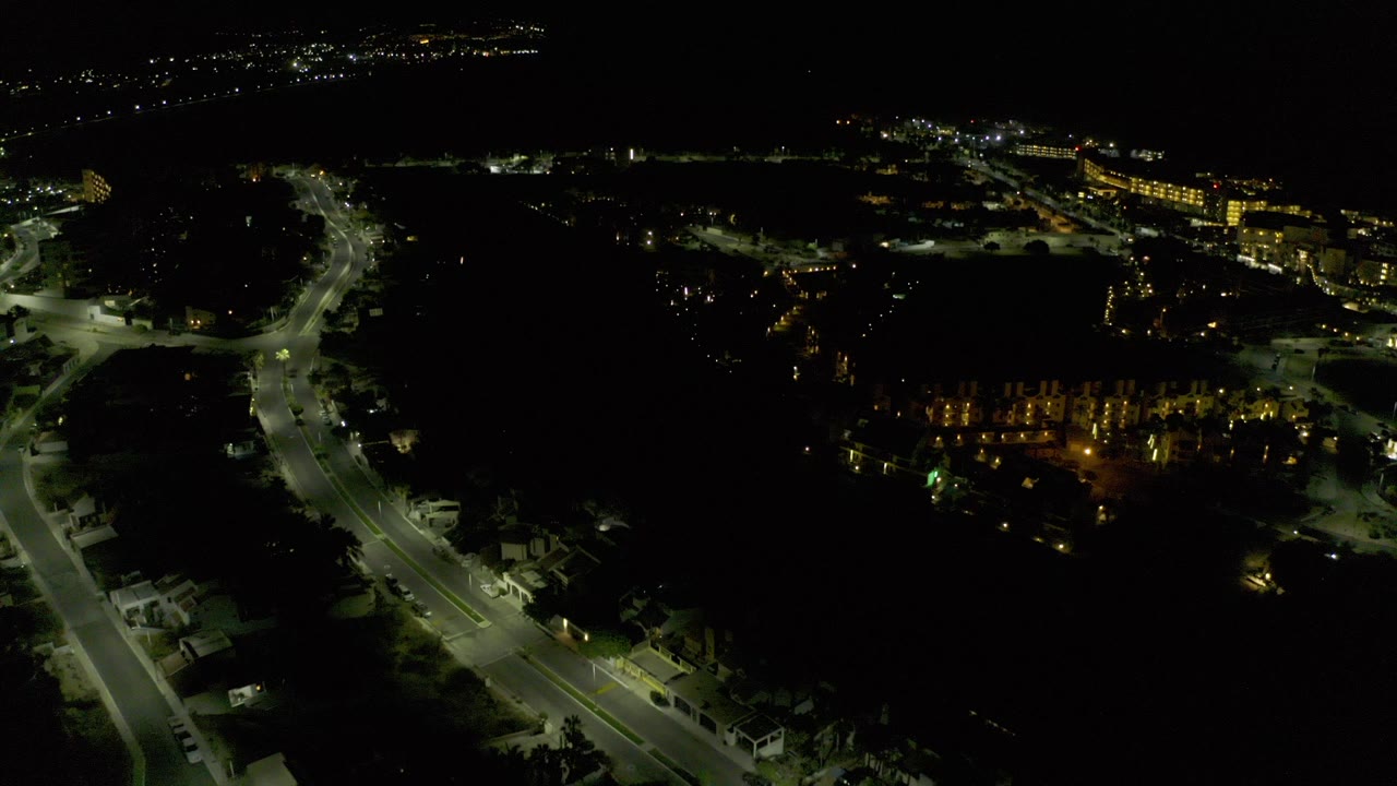 Night aerial view of lit roads and dark city blocks.