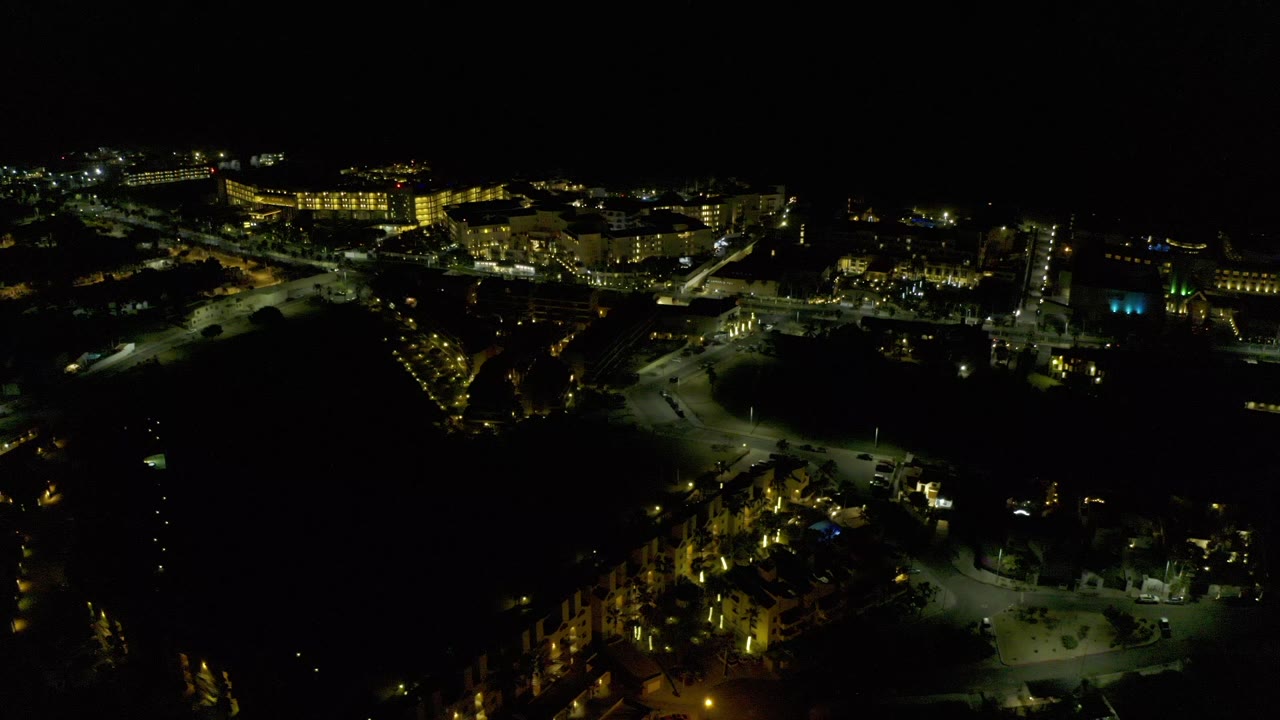 Night aerial view of lit campus buildings and dark foreground grounds