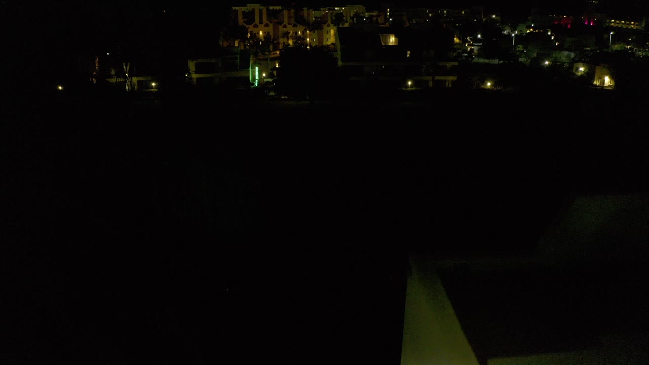 Dark nighttime view with small distant building lights