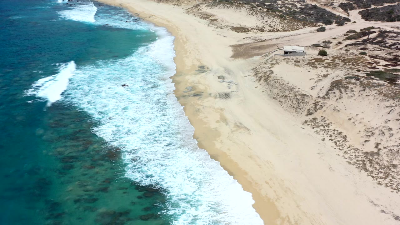 Aerial view of waves breaking along a sandy beach