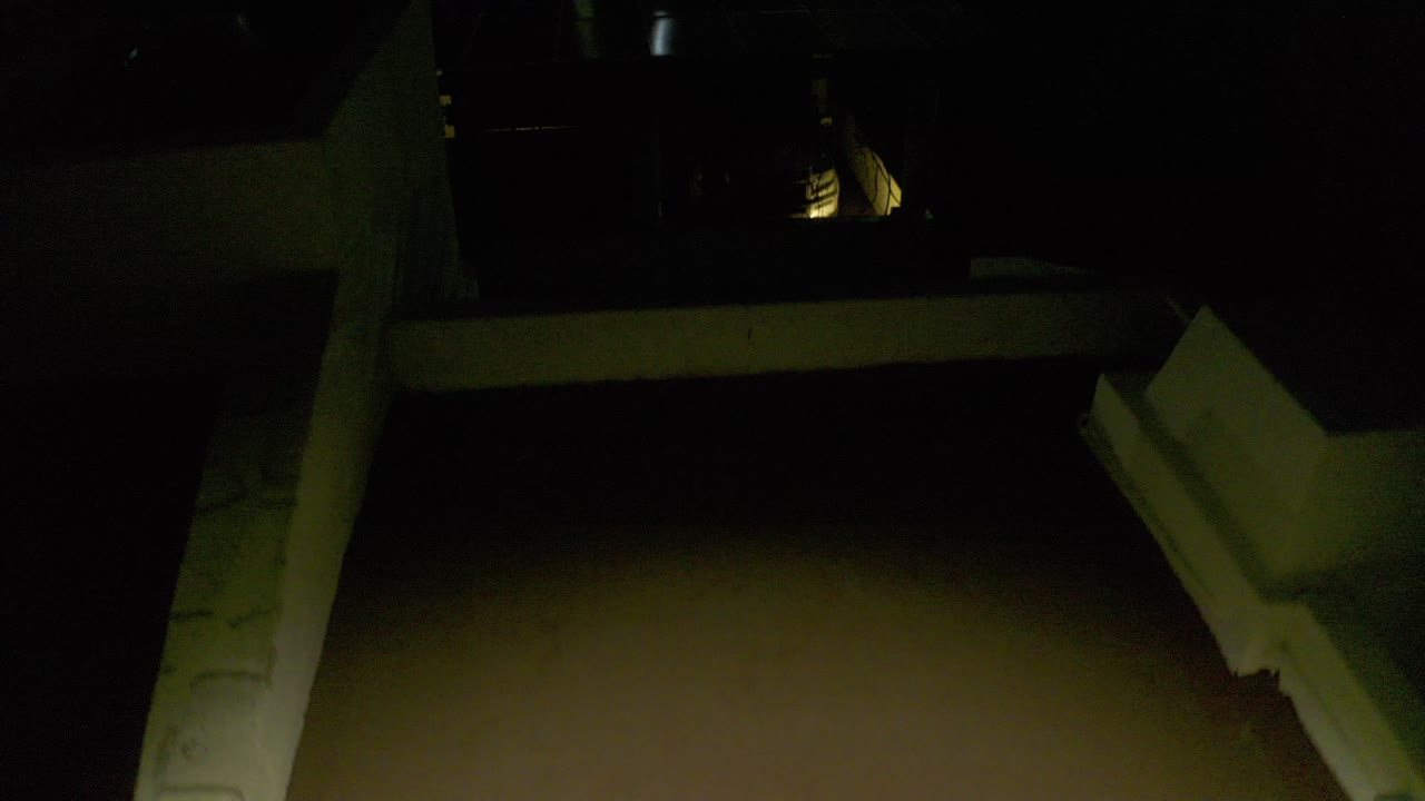 Opening frame of a dark rooftop or terrace edge in Los Cabos at night, with a few distant exterior lights and no visible people.
