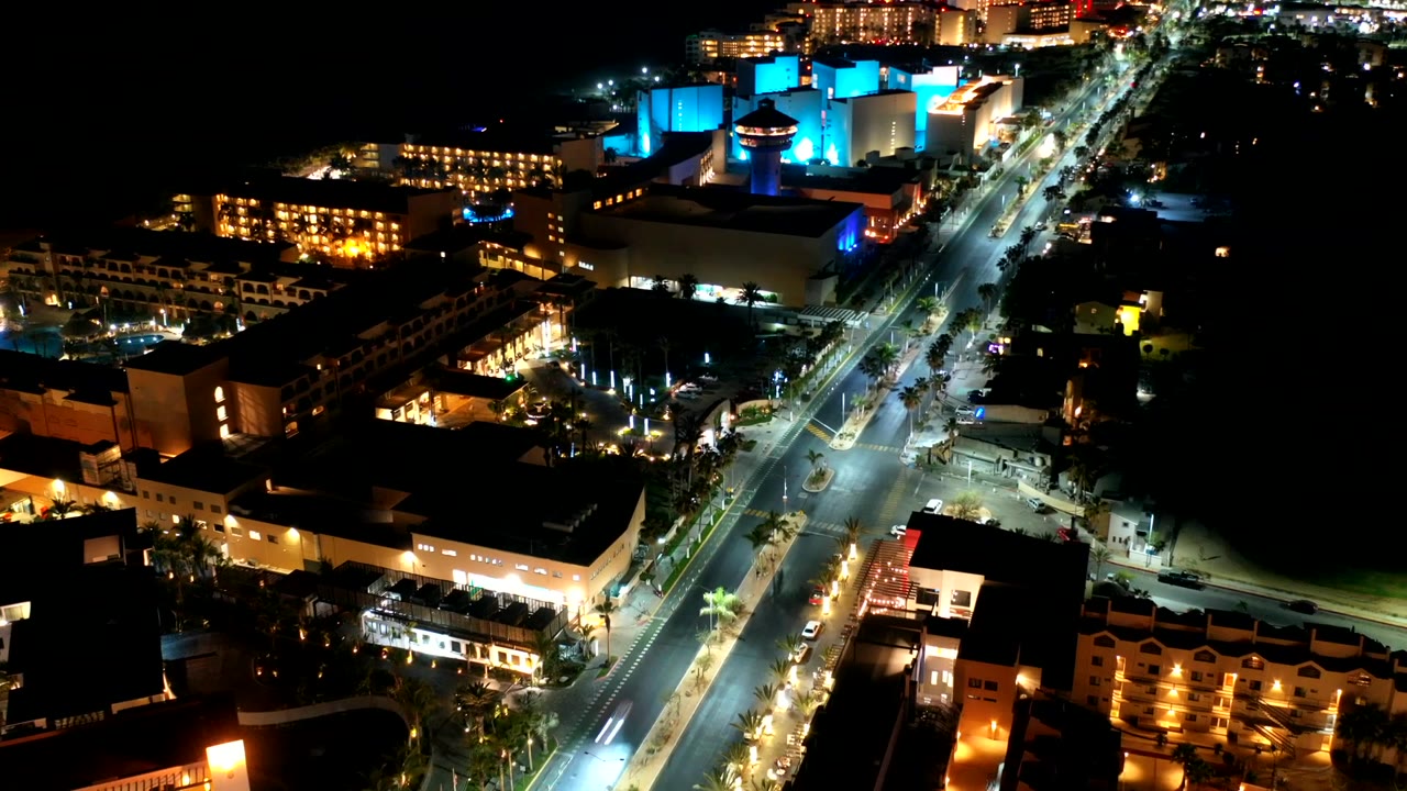 Elevated view of bright streets beside dark coastline