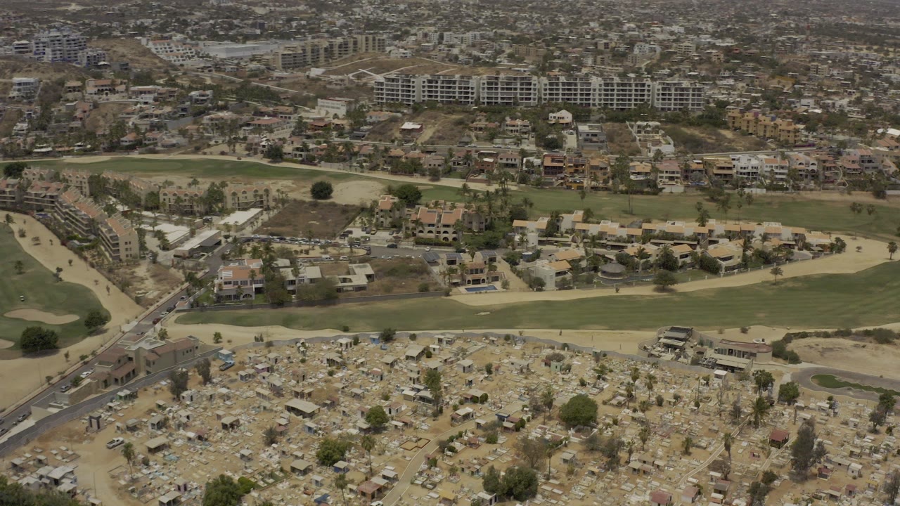 Aerial view of cemetery grounds, golf course, and hillside buildings.