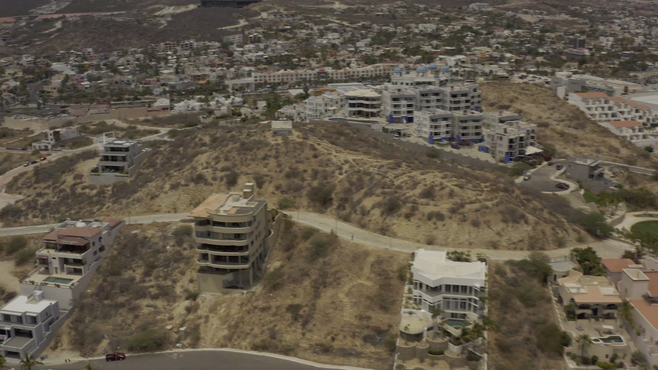 Aerial view of dry hillside homes and winding roads.