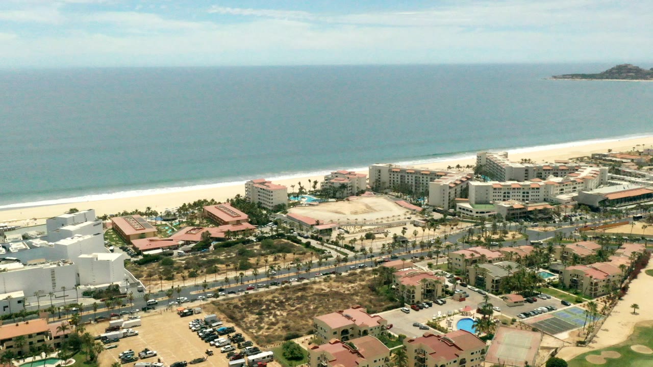 Aerial view of beachfront hotels, roads, beach, and sea.