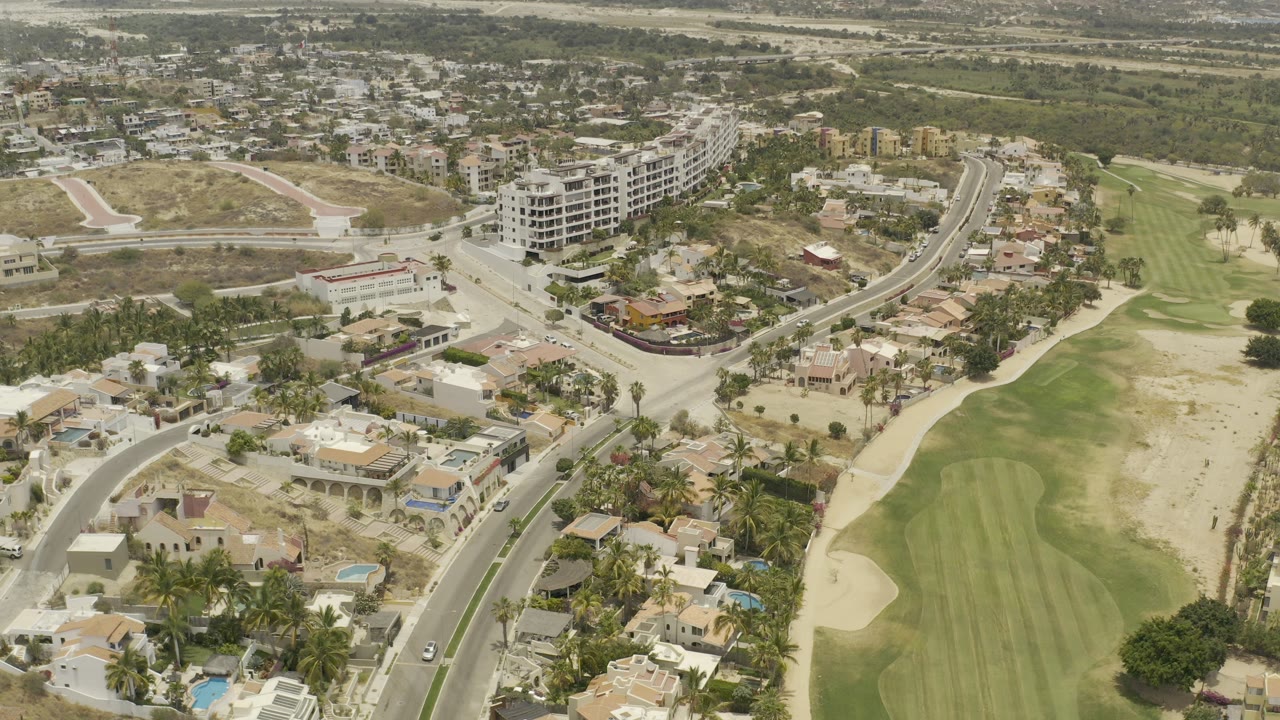 Aerial view of a road beside homes and a golf course.