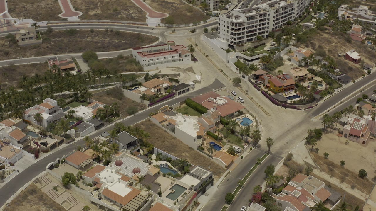 Aerial city view with homes, roads, and large buildings.