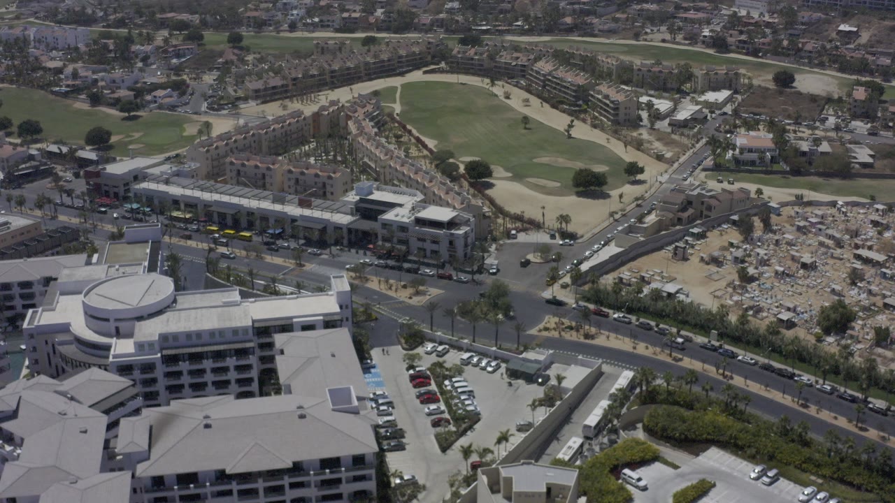 Aerial view of a large building complex, streets, parking lots, and surrounding development.