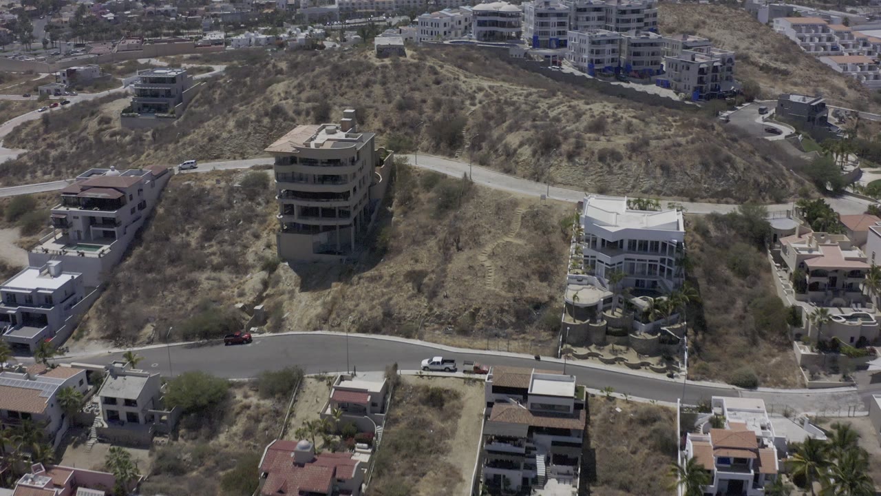High view of hillside residences, construction lots, and winding streets.