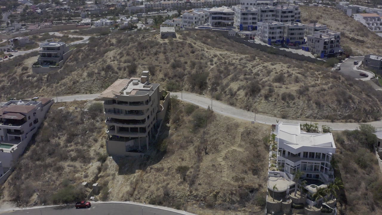 Aerial view of dry hillside homes and winding roads.
