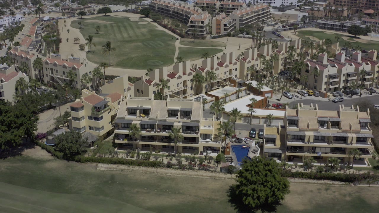 Aerial view of resort buildings beside a golf course.