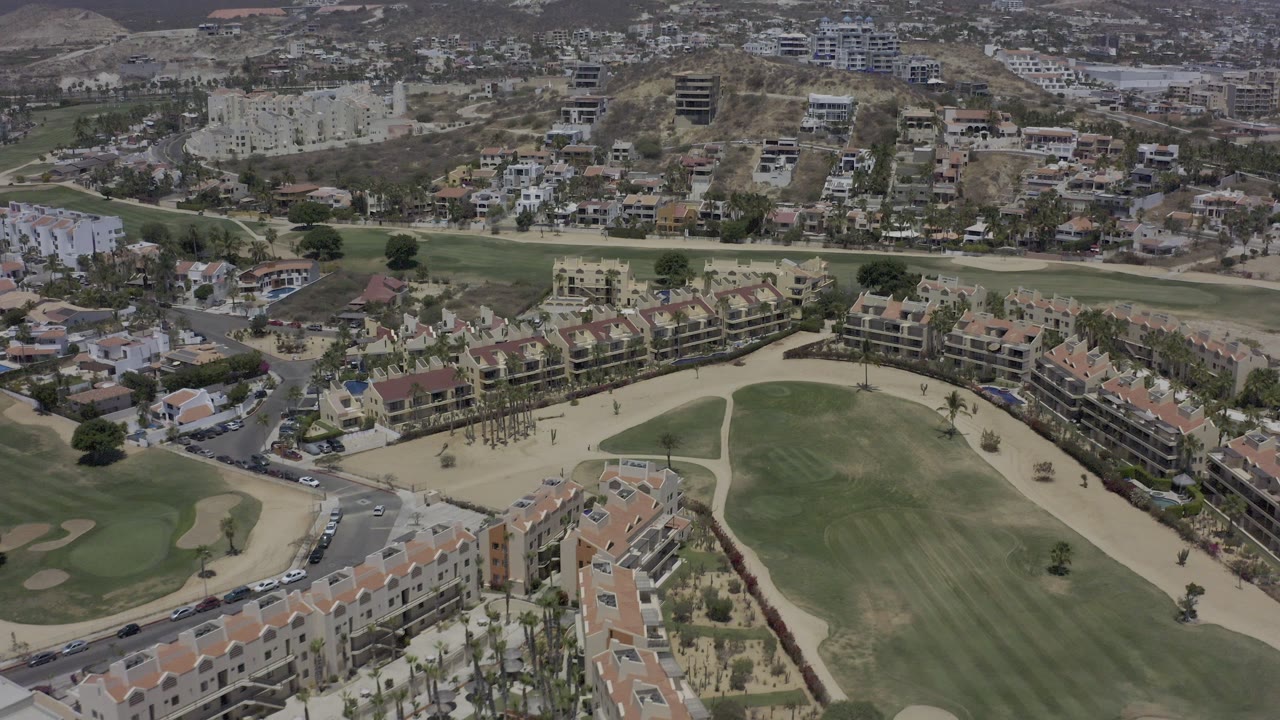 Aerial view of homes around a golf course and hillside neighborhoods.