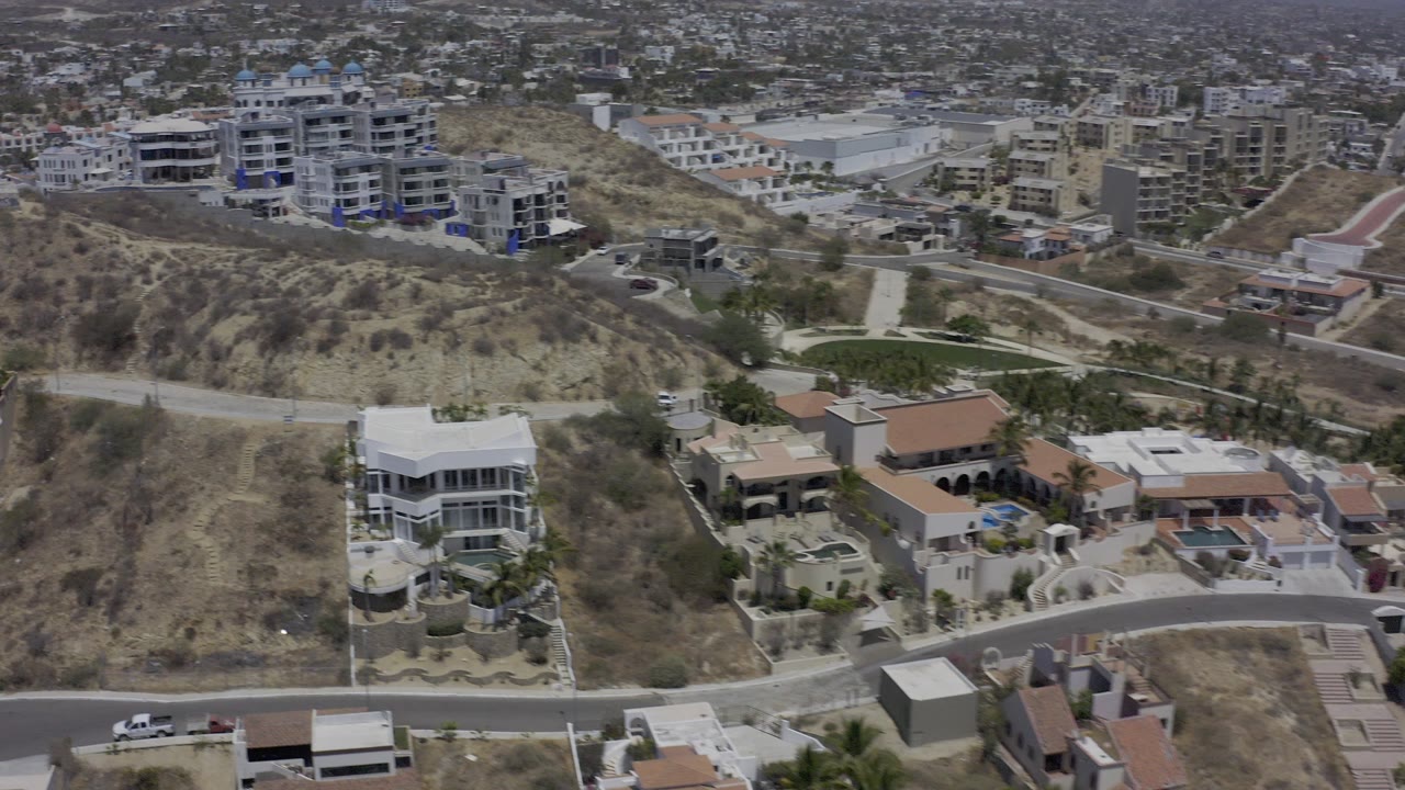 Aerial view of hillside homes, roads, and dense city buildings