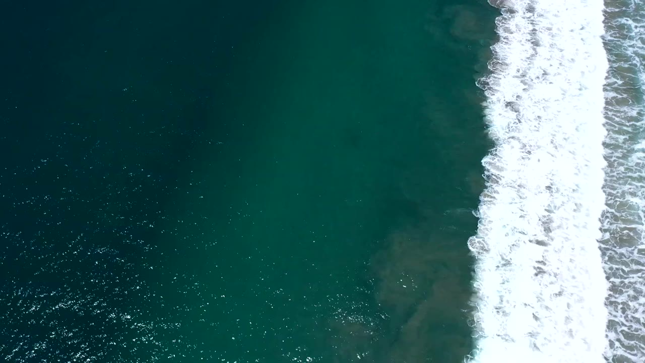 Green sea with bright surf foam at the edge