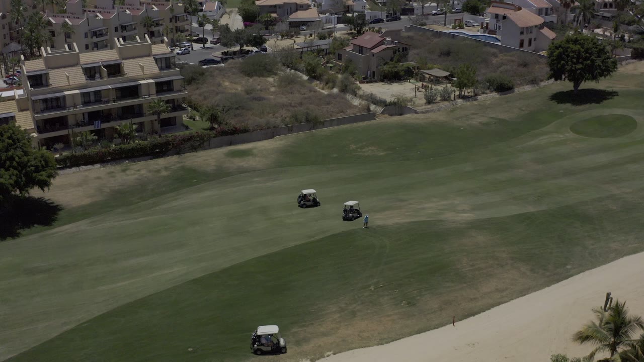 Three golf carts gathered on a green fairway