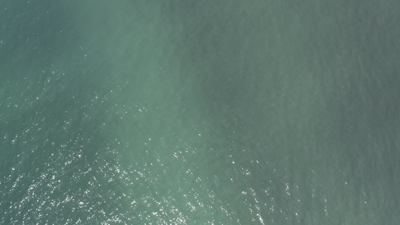 Glistening blue-green sea surface from above
