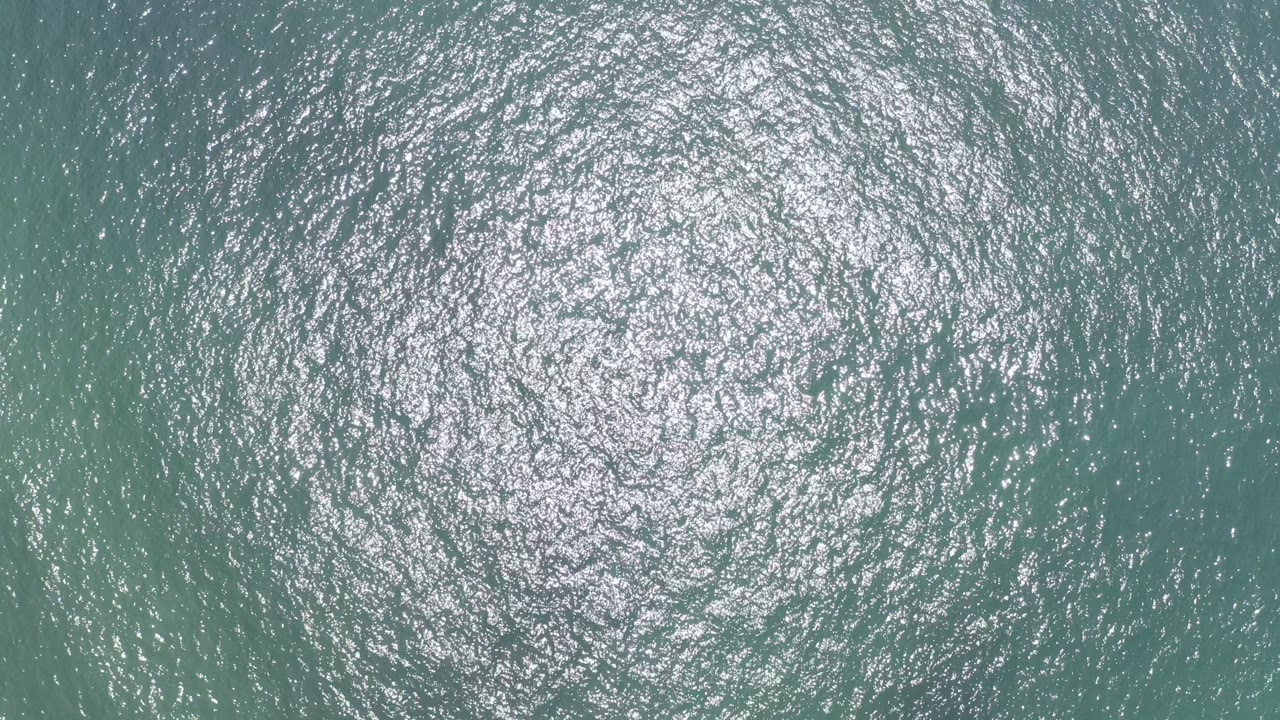 Ocean ripples with bright reflection high in frame