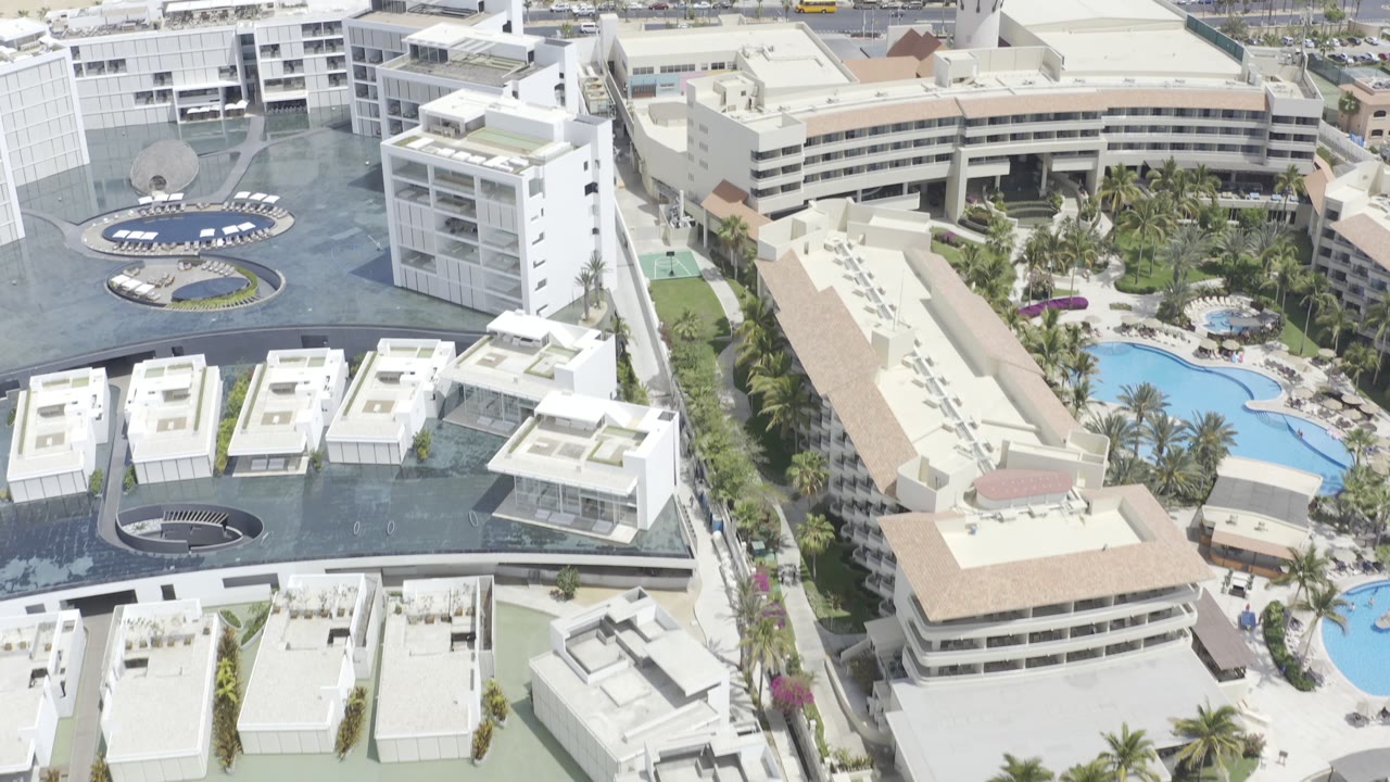 Drone view of resort complex with circular driveway and pools.