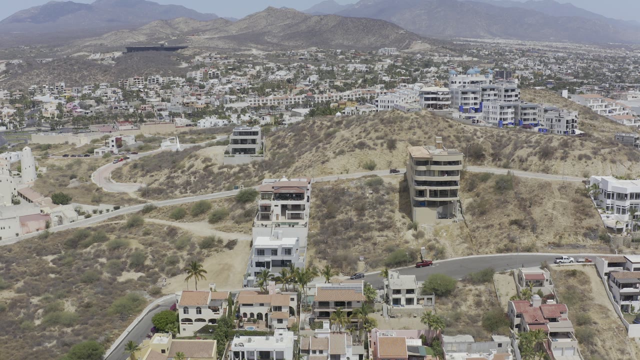 Aerial view of homes and roads around a dry sandy hill