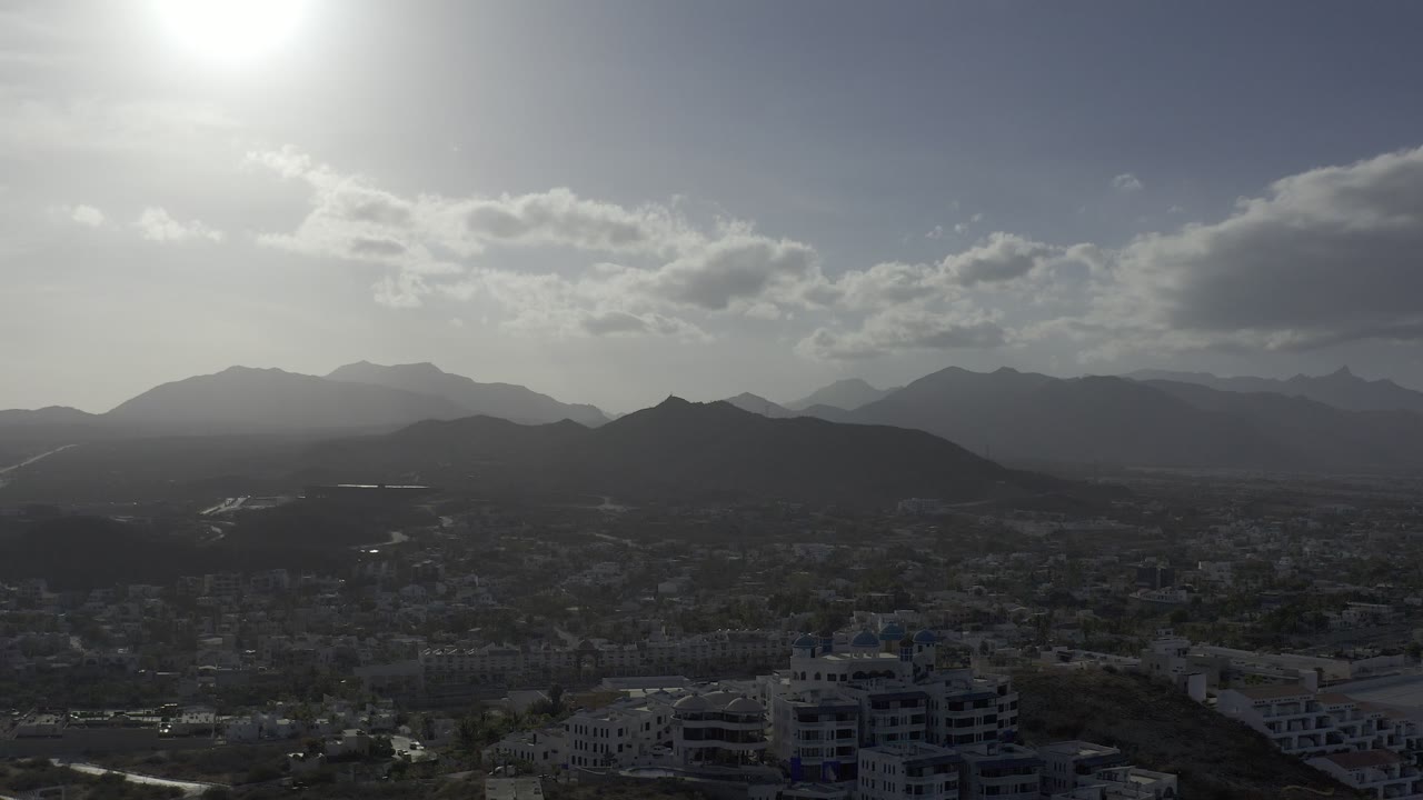 Hazy mountains behind a low city skyline.