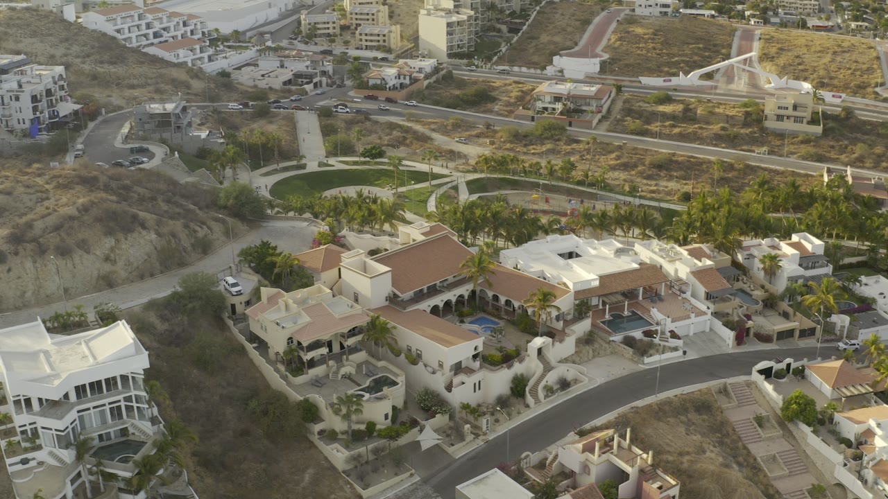 Overhead view of hillside villas and a white apartment building