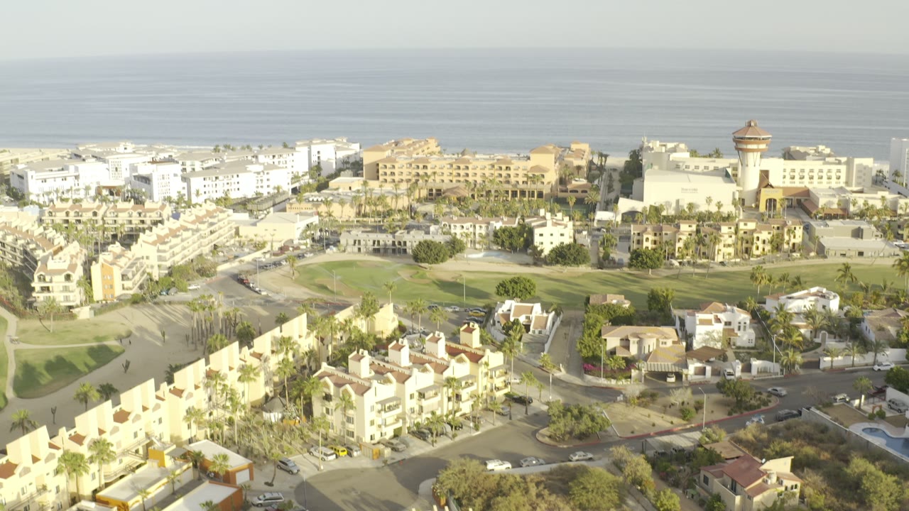 Aerial view of coastal homes, resort buildings, and sea