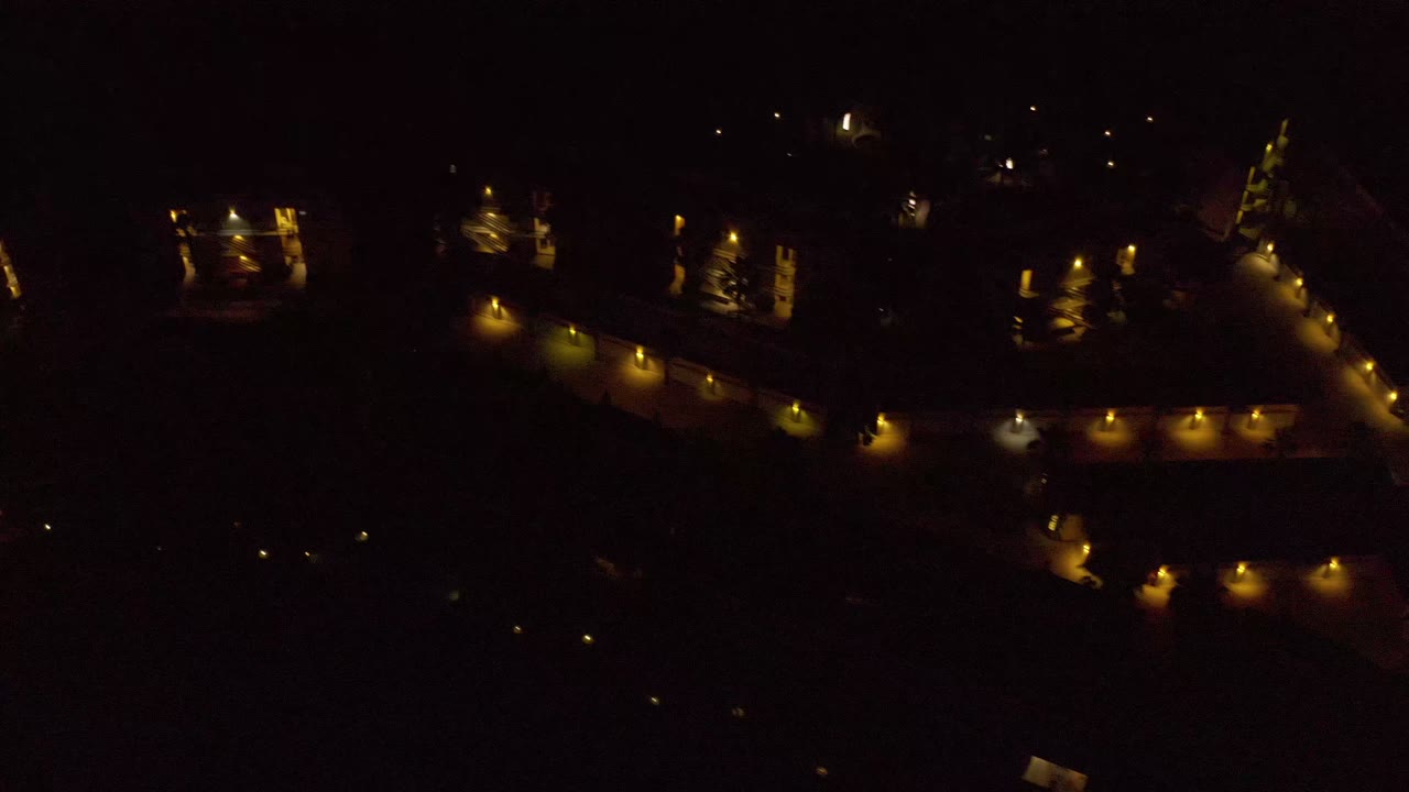 A second Los Cabos night frame shows clustered warm exterior lights running along dark building-like shapes, with no visible people.
