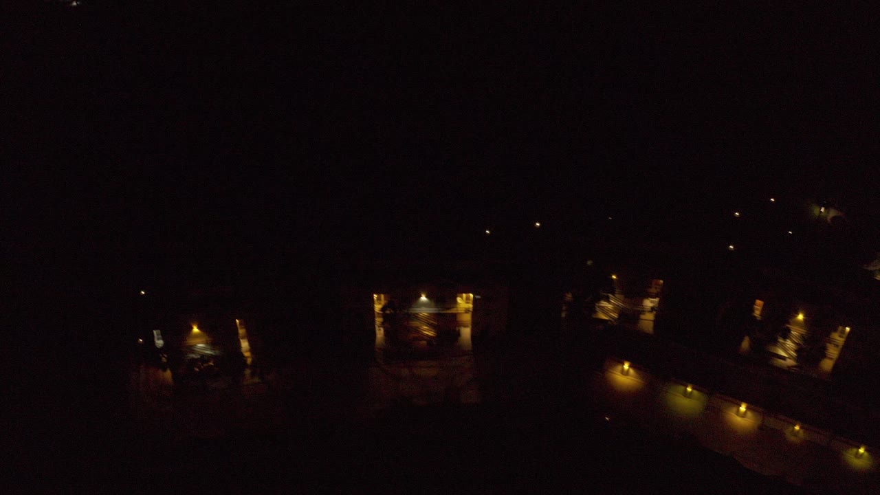 Dark overhead night view with warm lights from large homes
