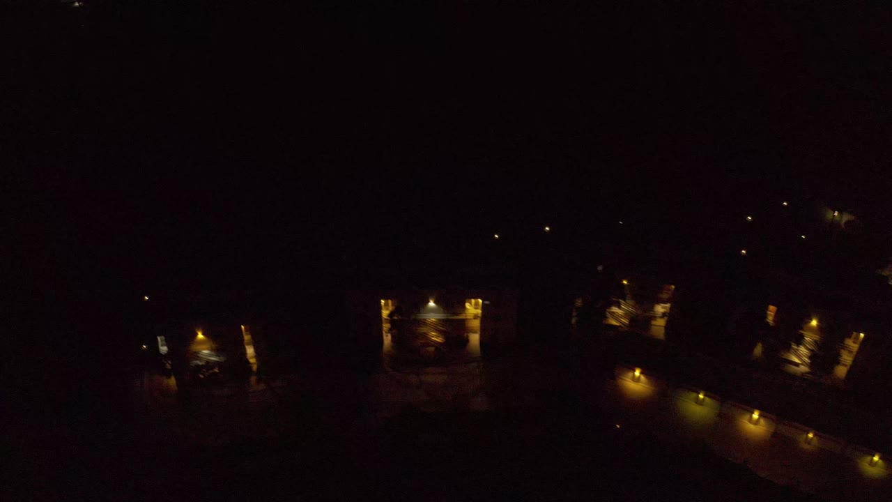 Second frame shows warm porch and exterior lights grouped around large residential structures in Los Cabos, Mexico, with no visible people.