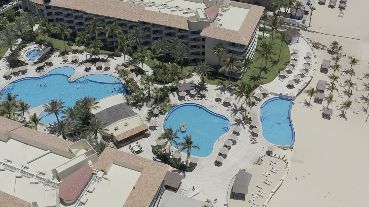 Resort pool courtyard seen from above in bright sunlight.