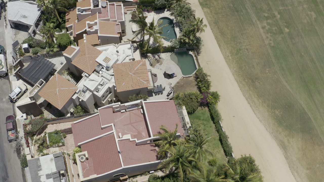 Overhead view of homes beside a pale green landscaped strip.