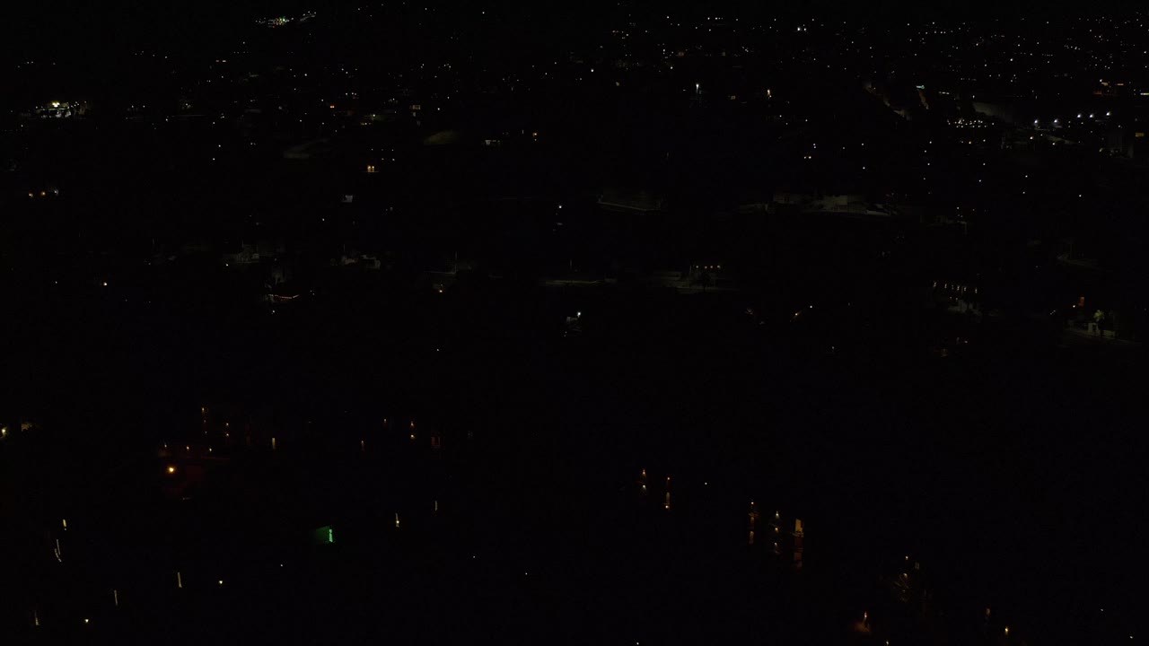 Very dark night view with scattered distant lights.