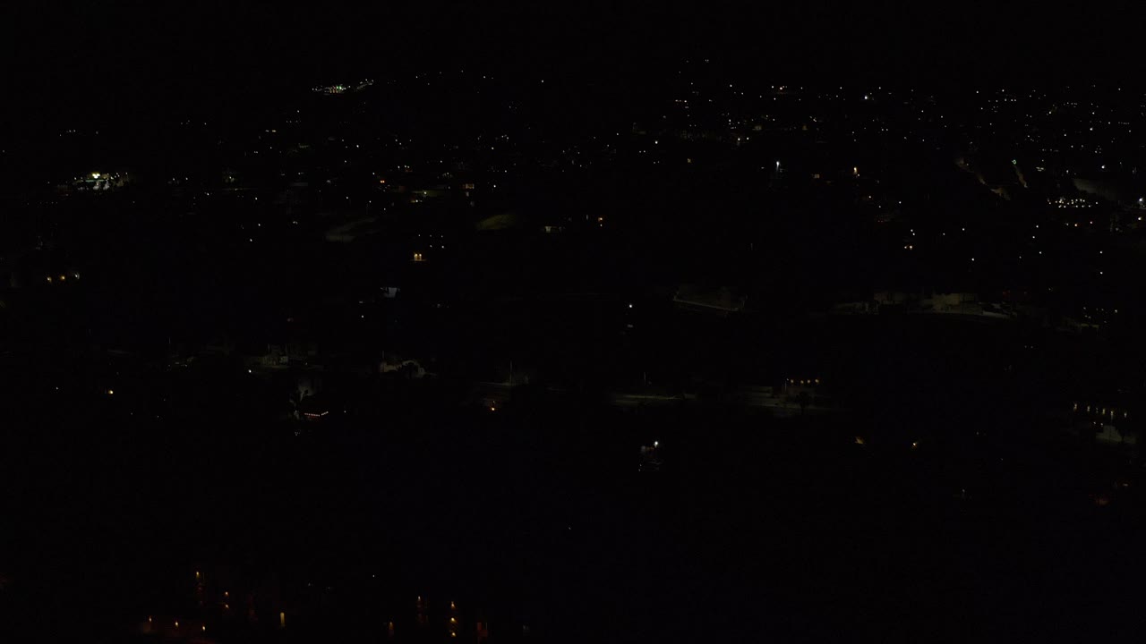 Very dark city lights scattered across a distant night view.