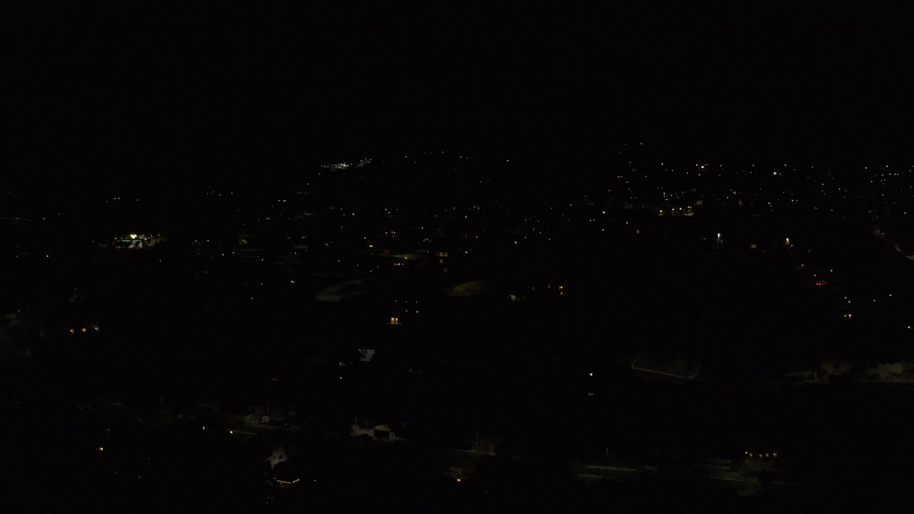 Dark aerial city view with scattered lights