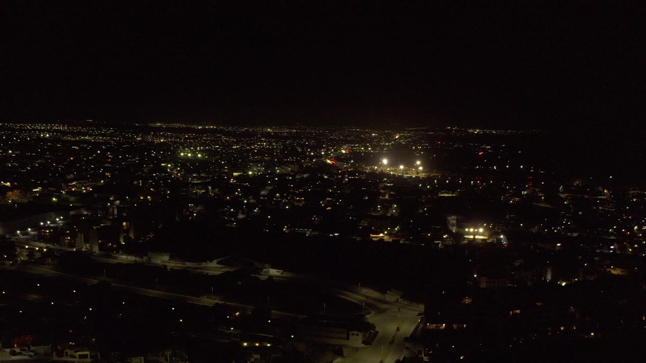 Wide nighttime city lights under a black sky