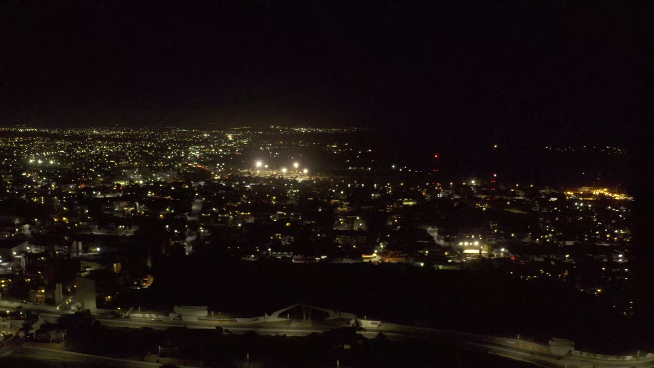 Los Cabos, Mexico appears as a broad night cityscape, with concentrated bright lights near the horizon, darker streets in front, and no visible people.