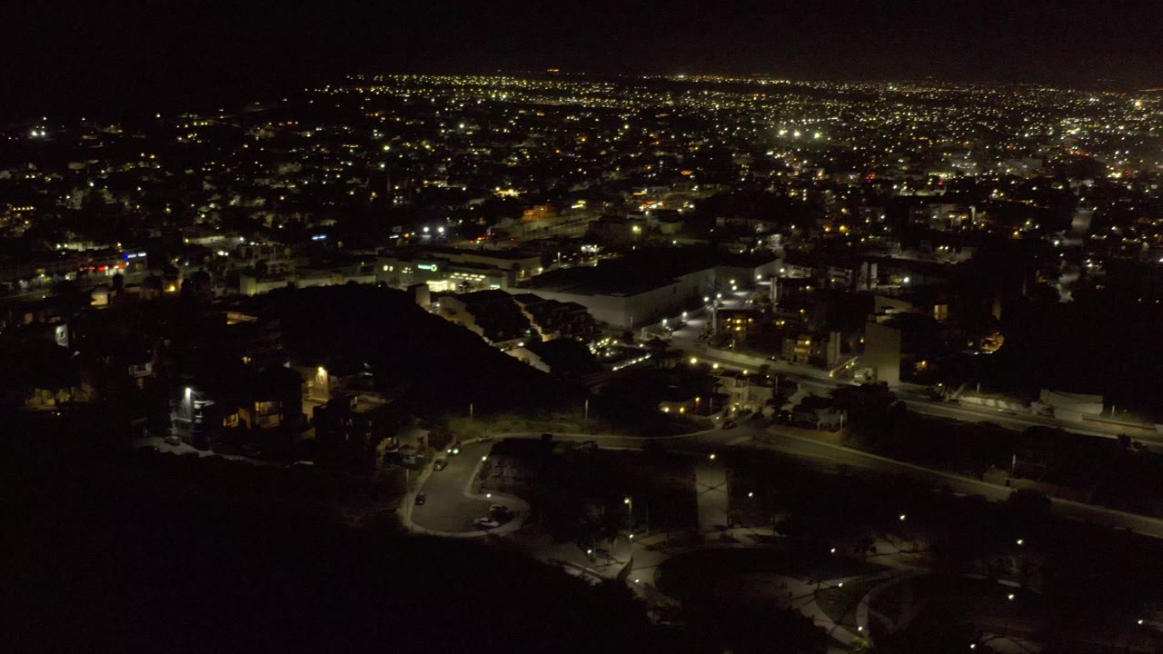Elevated night view across a dense city light grid