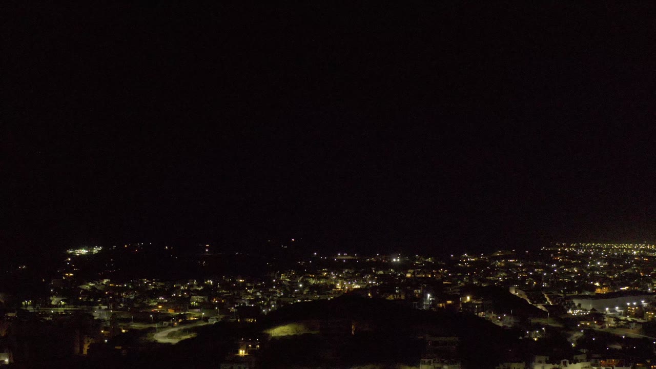 Wide dark view over scattered city lights at night.
