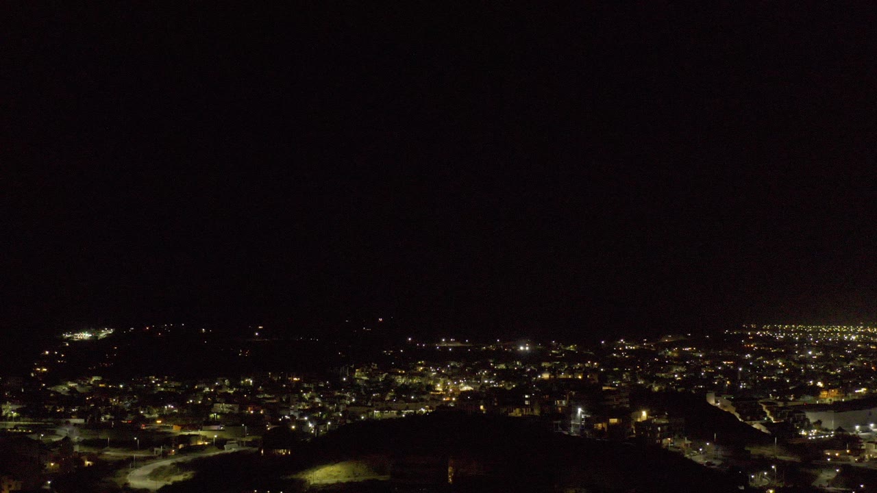 Wide night view of city lights under a dark sky