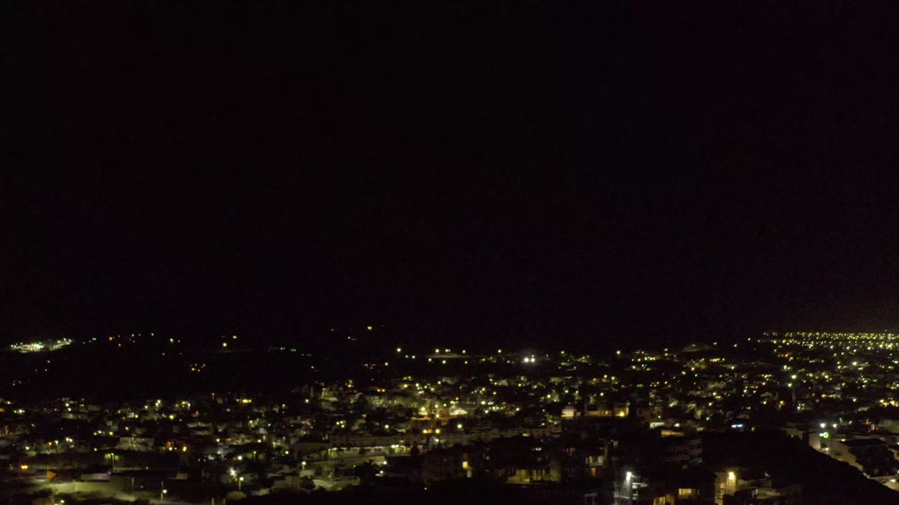 Los Cabos night lights appear slightly shifted across the middle of the frame, with black sky above and no visible people.