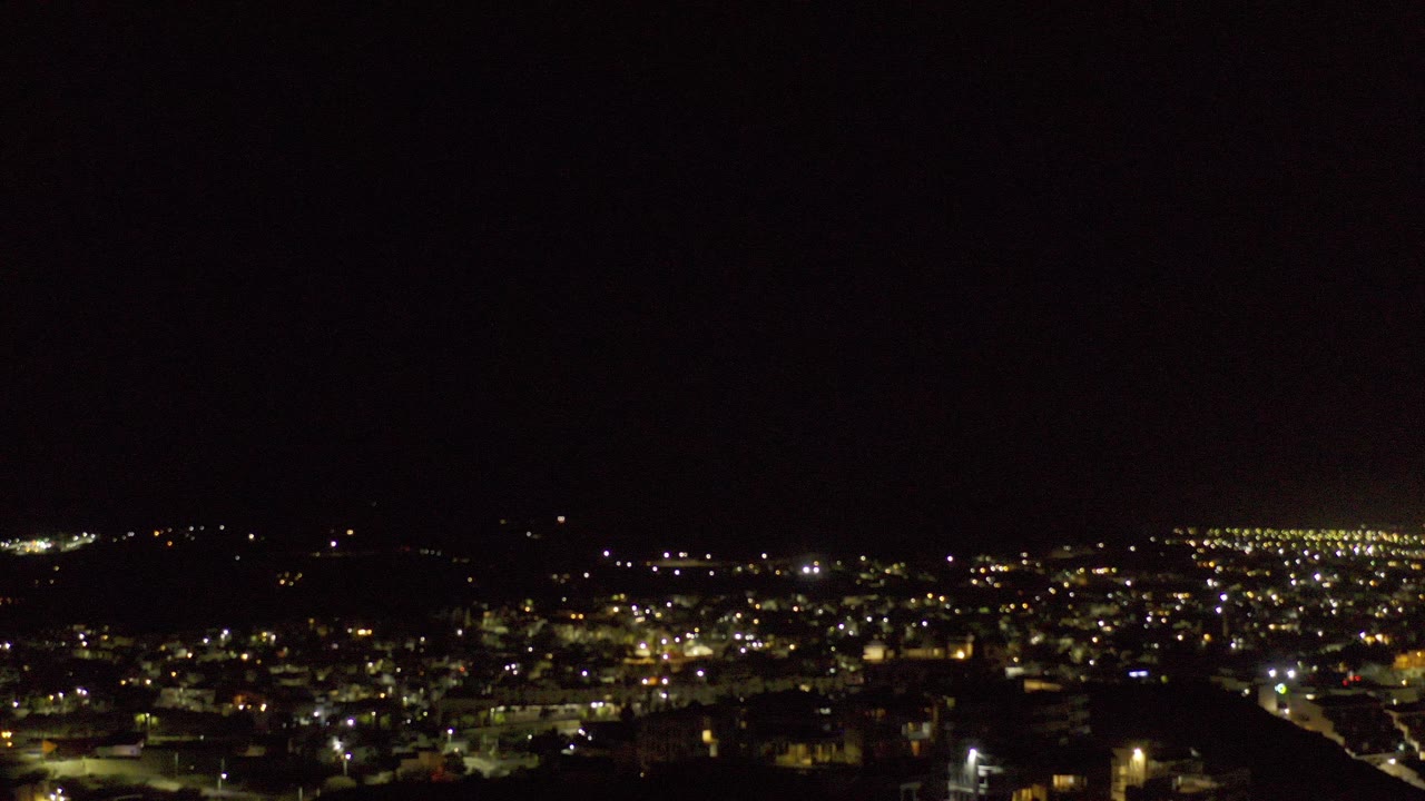 Distant town lights beneath a black night sky.