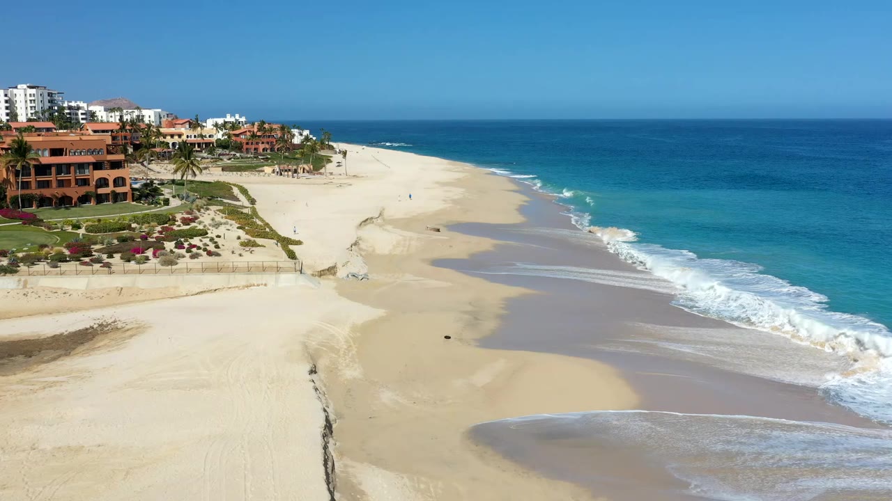 Elevated view of sandy beach, turquoise ocean, and resort buildings